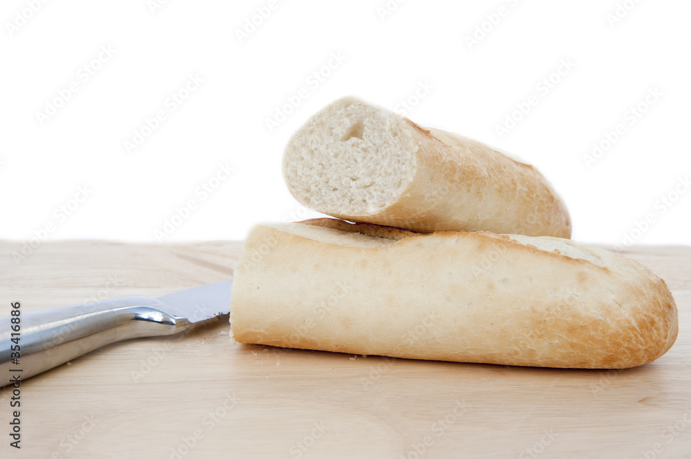 Baguette and bread knife on chopping board isolated on white Baguette and bread knife on chopping board isolated on white