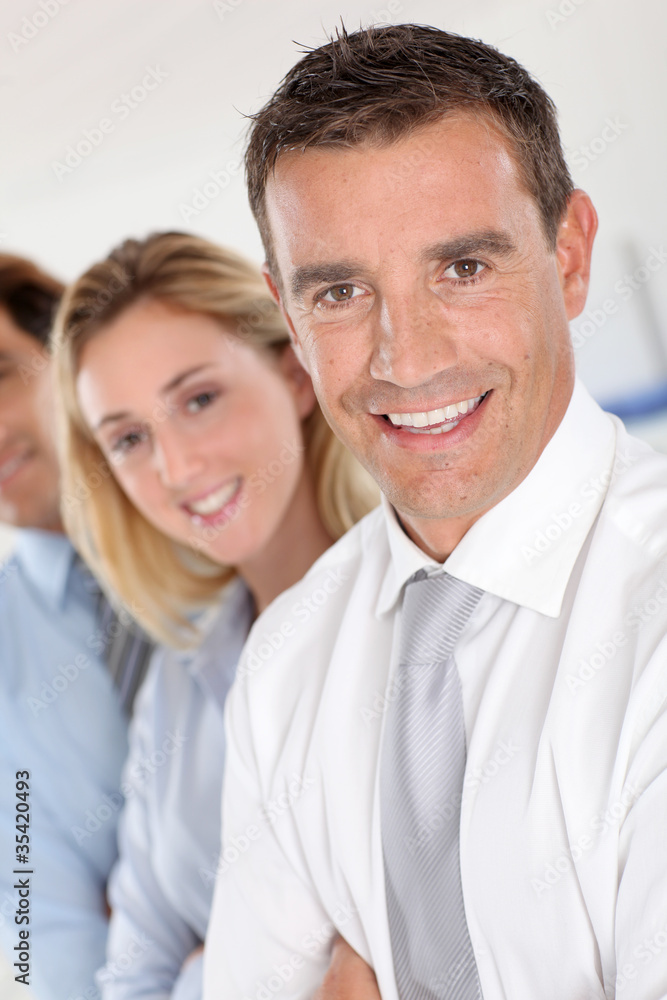 Portrait of businessman standing in front of group Portrait of businessman standing in front of group