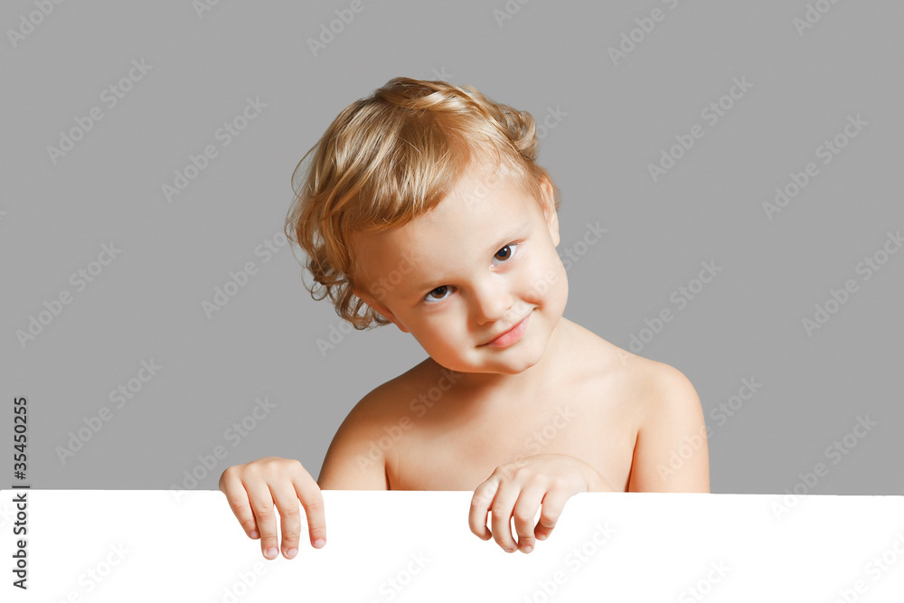 Little cute boy holding a white blank