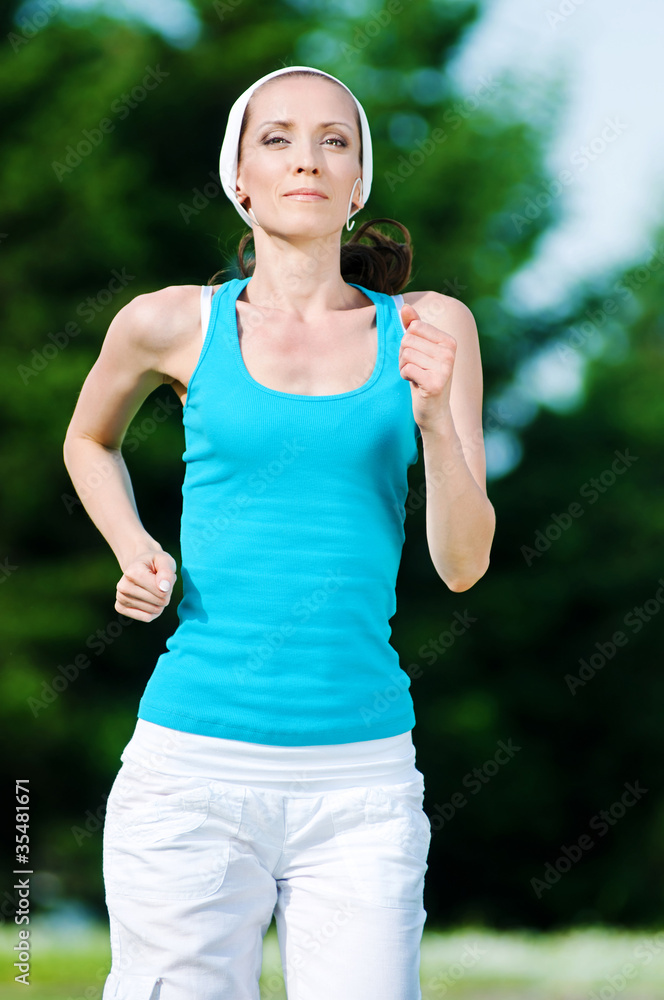 Beautiful woman running in green park Beautiful woman running in green park