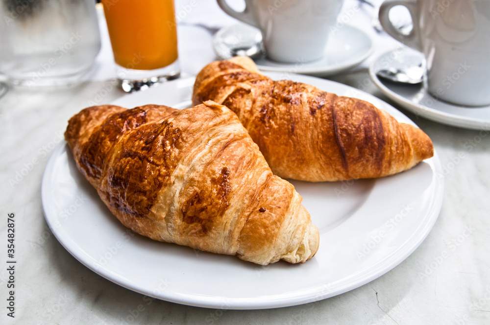 Breakfast with coffee and croissants in a basket on table Breakfast with coffee and croissants in a basket on table