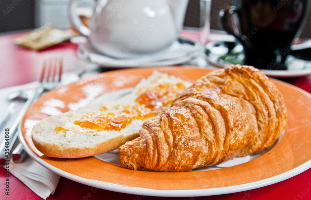 Breakfast with coffee and croissants in a basket on table Breakfast with coffee and croissants in a basket on table