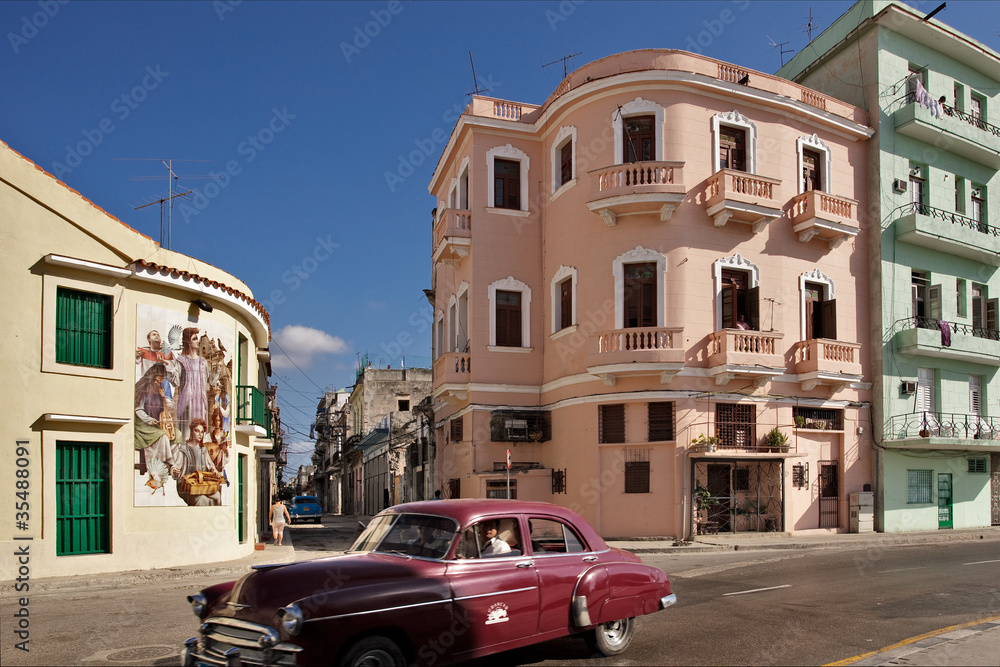 Red car and pastel-colored houses in Havana