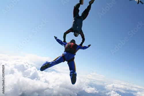 Two skydivers exit an airplane