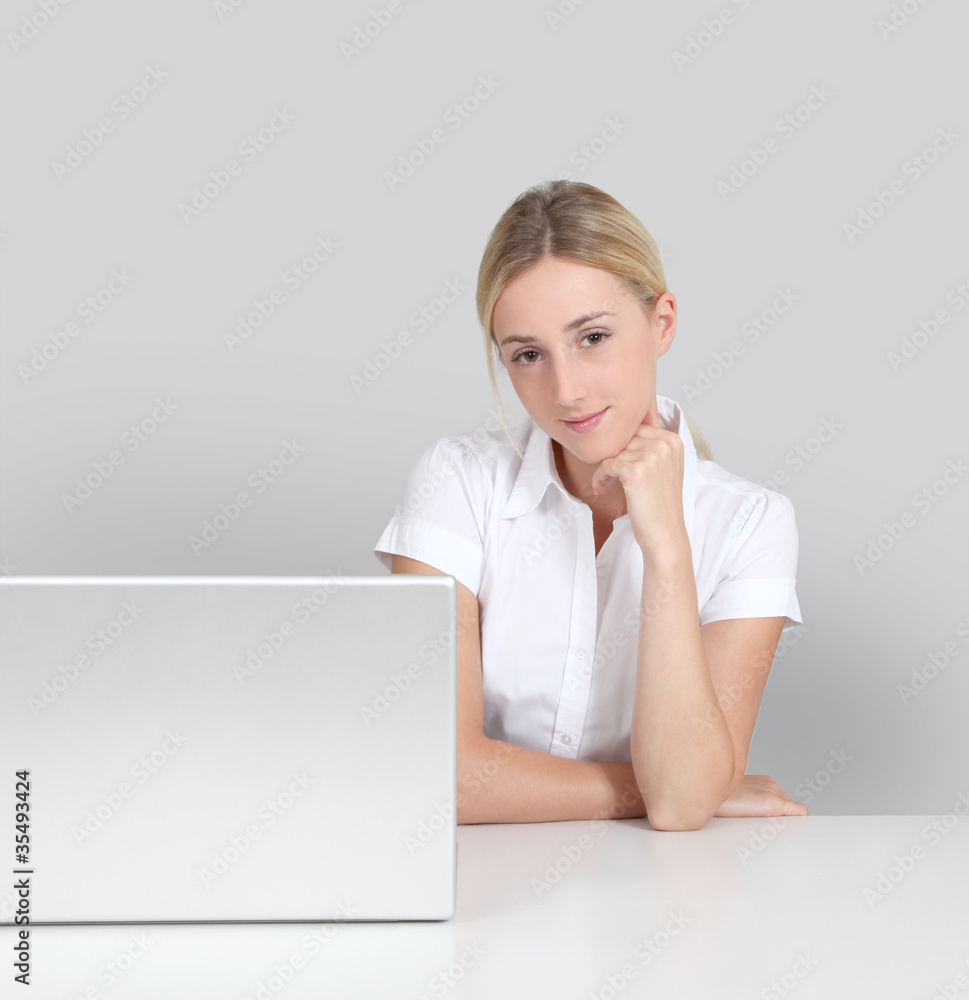 Portrait of woman sitting by laptop computer Portrait of woman sitting by laptop computer