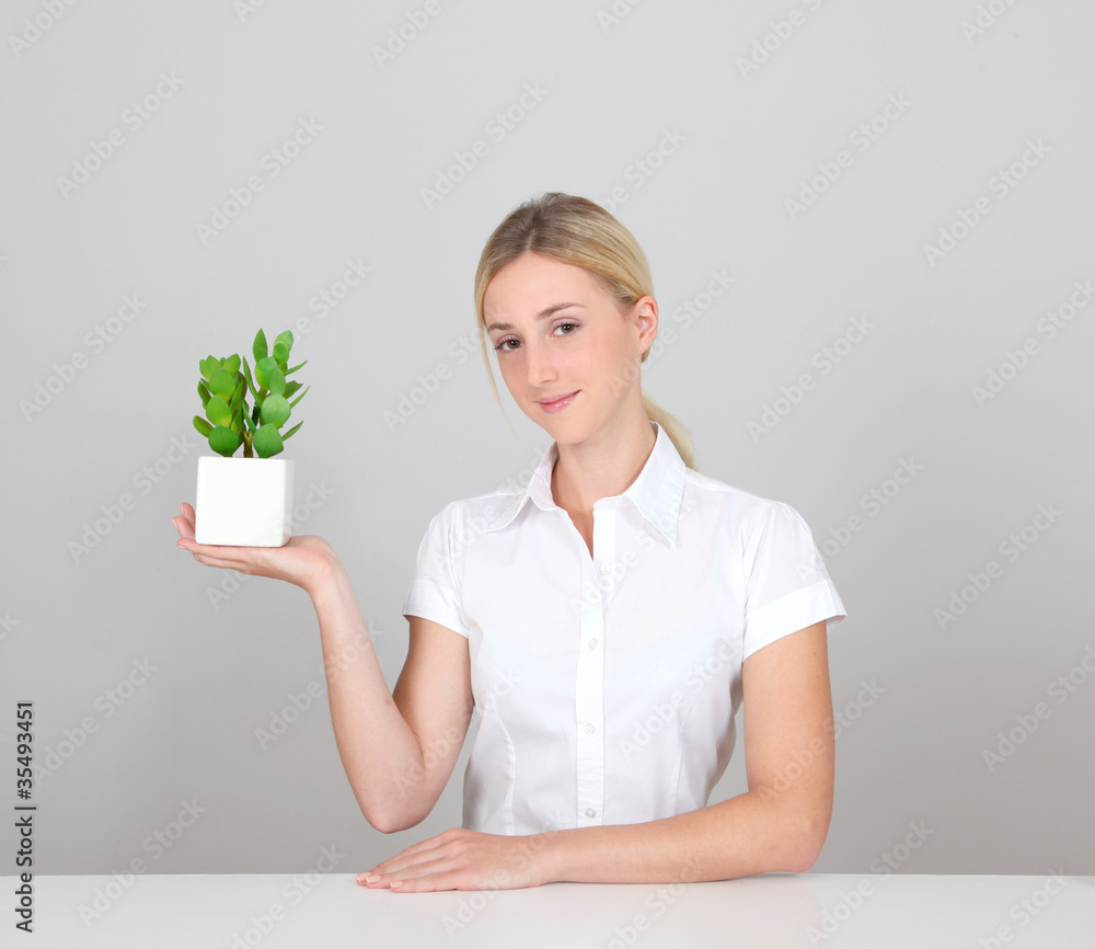 Woman holding green plant on white background Woman holding green plant on white background