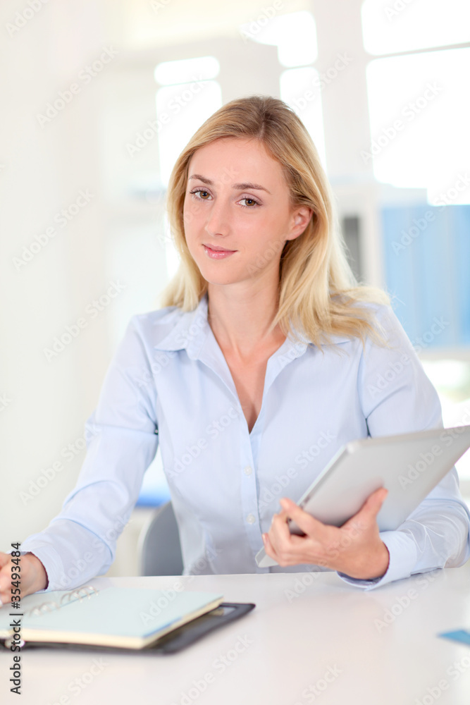Office worker sitting at table with agenda and touchpad Office worker sitting at table with agenda and touchpad