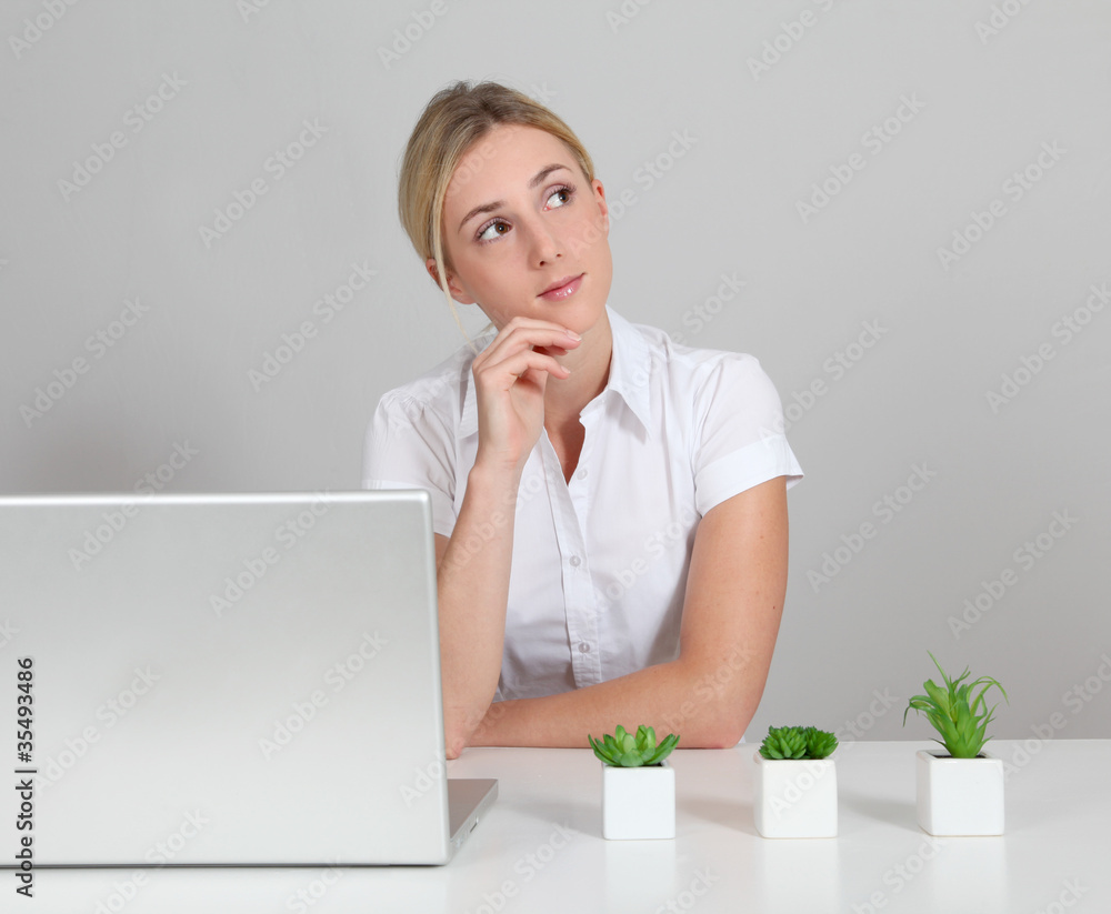 Blond woman sitting by computer and green plants Blond woman sitting by computer and green plants