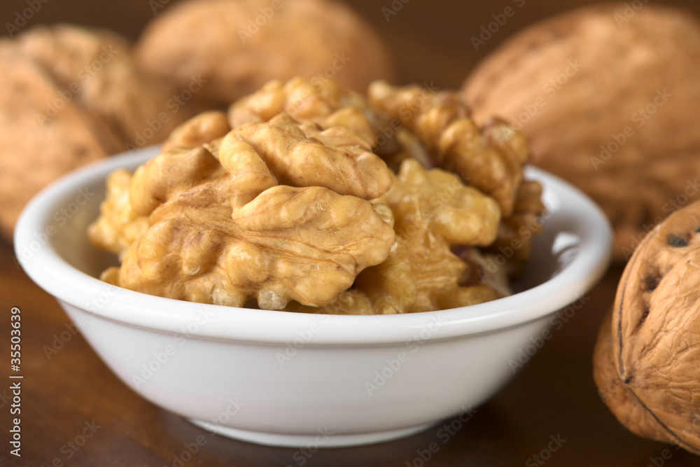 Walnut halves (lat. Juglans regia) in white bowl Walnut halves (lat. Juglans regia) in white bowl