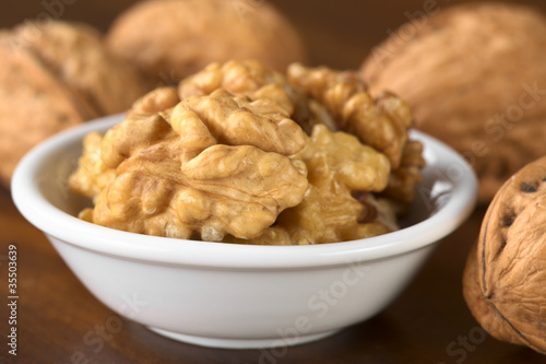 Walnut halves (lat. Juglans regia) in white bowl