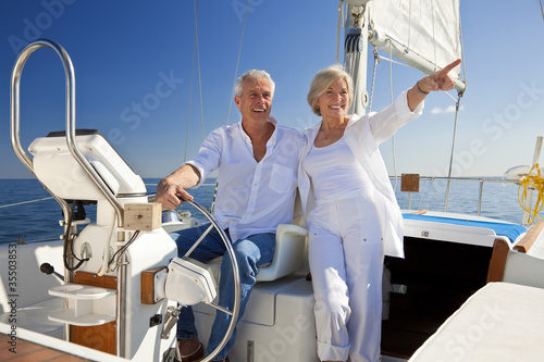 Happy Senior Couple At The Wheel of a Sail Boat © spotmatikphoto