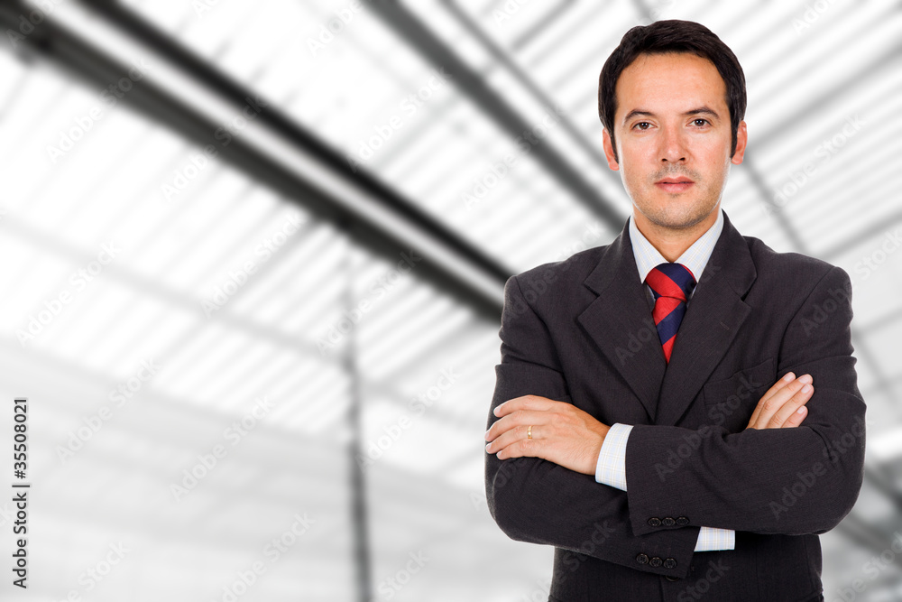 Closeup portrait of a smiling business man standing at a modern Closeup portrait of a smiling business man standing at a modern