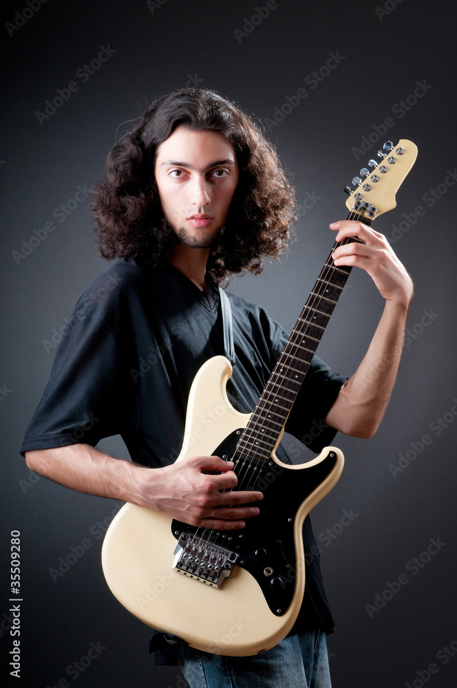 Obraz premium Guitar player against the dark background