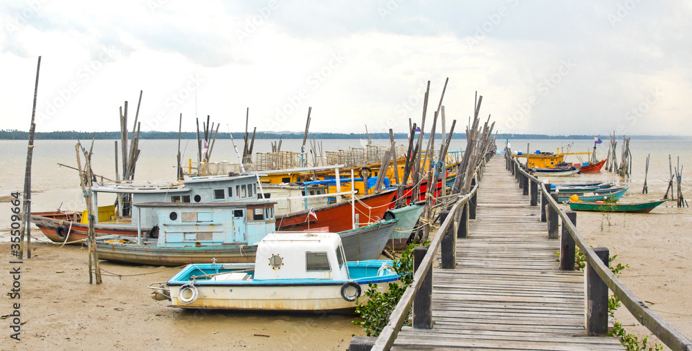Rugged Fishing Boats and Pier at Low tide in Malaysia