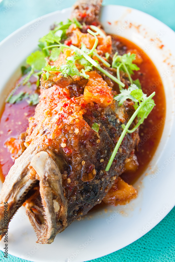 Fototapeta premium Fried grouper fish with sauce,sour and spicy on white plate,Thai