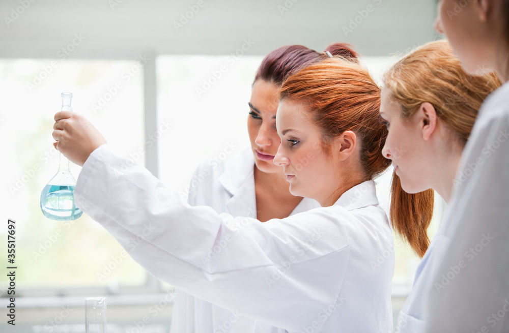 Fototapeta premium Cute chemistry students holding a flask