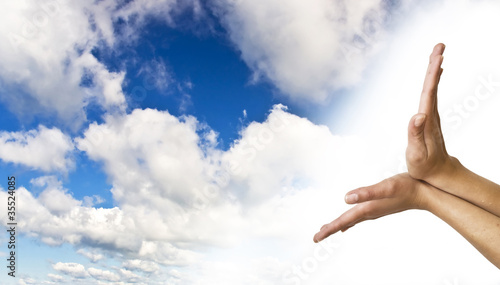Hands on blue sky background. Women's hands