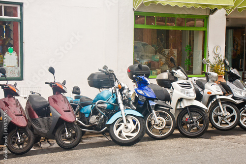 Canvas Print Line of Mopeds in Front of Shops