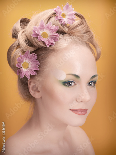 Portrait of beautiful girl blonde with flowers in her hair