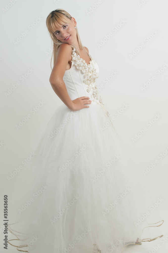 Studio portrait of a young bride wearing white wedding dress wit Studio portrait of a young bride wearing white wedding dress wit