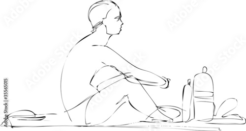 guy in swimming trunks sitting on the beach