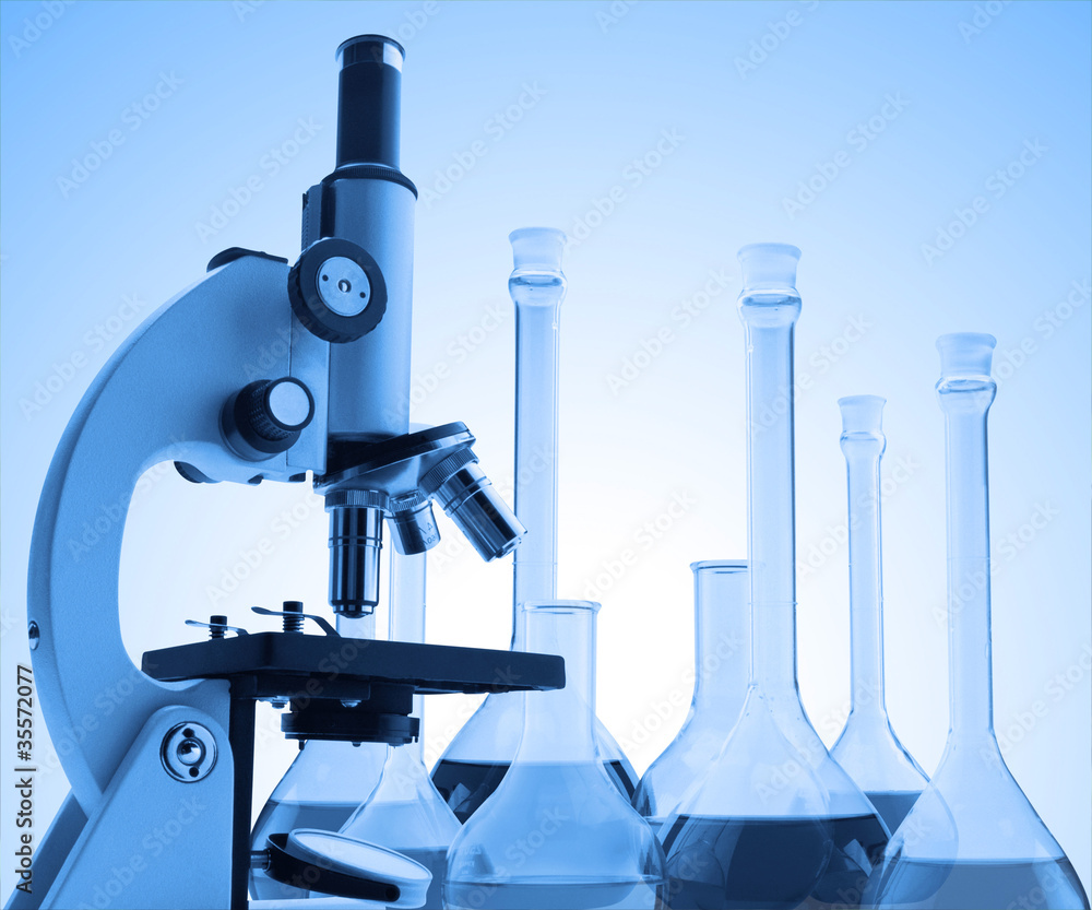 microscope and test tubes with liquid toning in blue color microscope and test tubes with liquid toning in blue color
