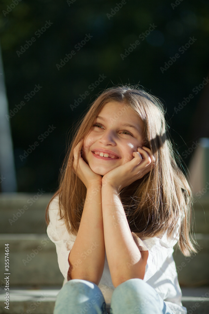 girl sits propped on his head with his hands and smiling