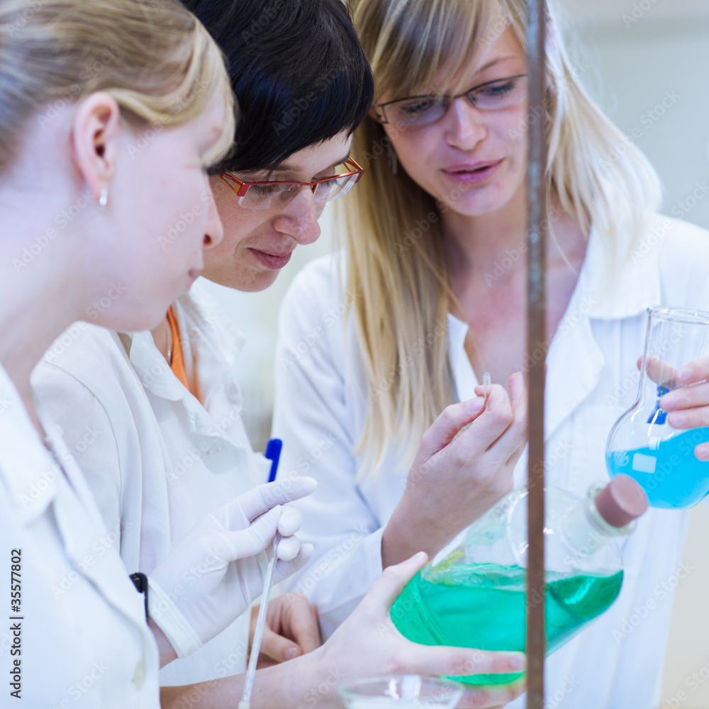 three researchers/chemistry students in a lab three researchers/chemistry students in a lab