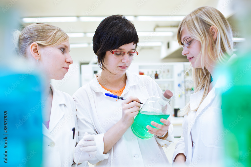 three researchers/chemistry students in a lab three researchers/chemistry students in a lab