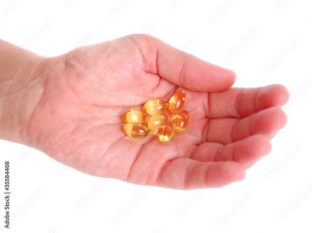 Woman hand full of Omega-3 fish oil capsules Woman hand full of Omega-3 fish oil capsules