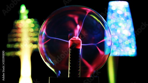 Energy lines move inside plasma ball, behind in two lamps photo