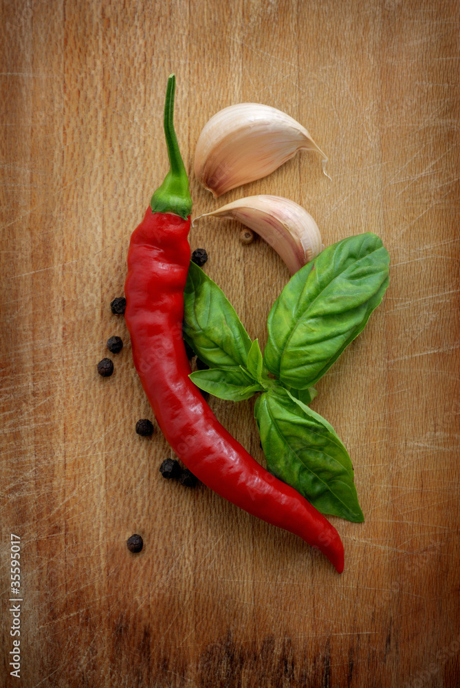 Red hot chili peppers, garlic and basil over wooden background Red hot chili peppers, garlic and basil over wooden background