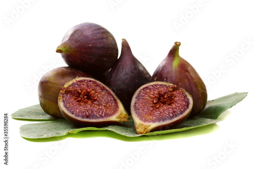 Figs with a green leaf on white background.