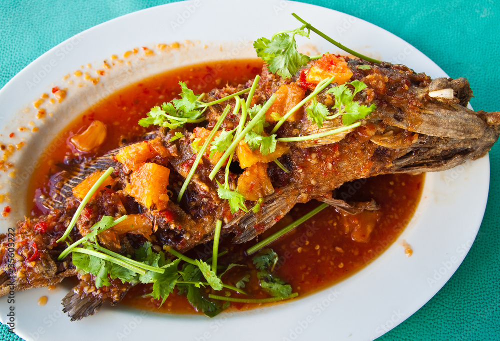 Fried grouper fish with sauce,sour and spicy on white plate,Thai Fried grouper fish with sauce,sour and spicy on white plate,Thai