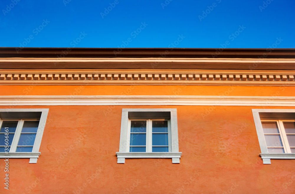 Traditional Italian orange house against the blue sky