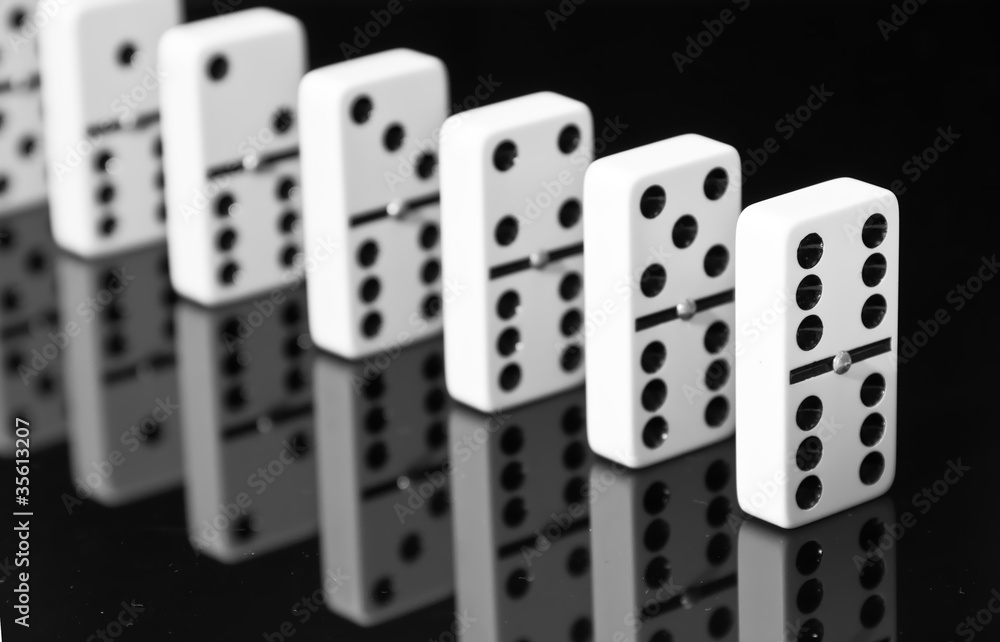 Dominoes on black shining surface Dominoes on black shining surface