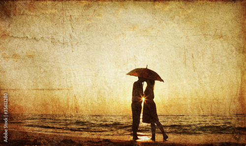 Couple kissing at the beach in sunset.