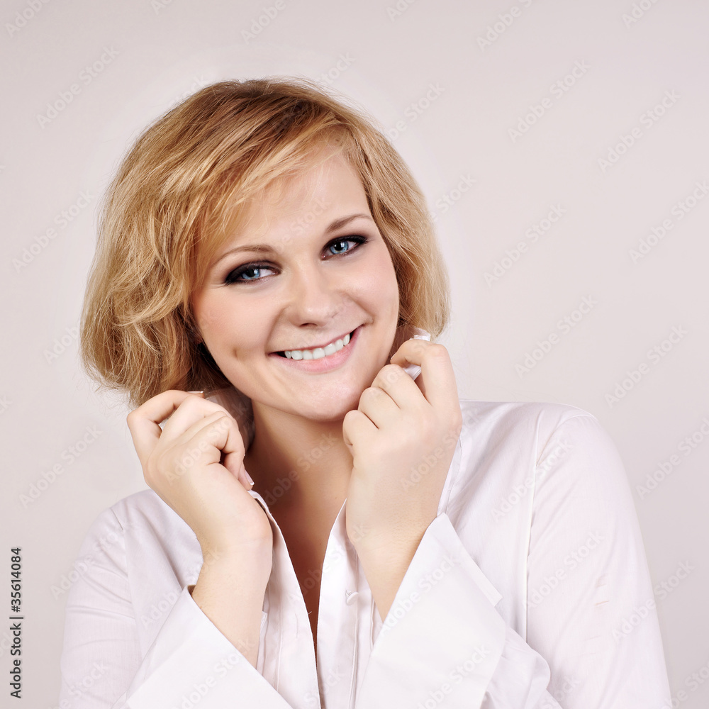 Smiling young blond haired woman with her hands near her face ho Smiling young blond haired woman with her hands near her face ho
