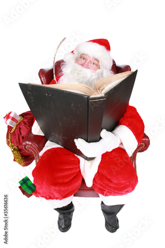 Santa writing in the book of names of good children photo