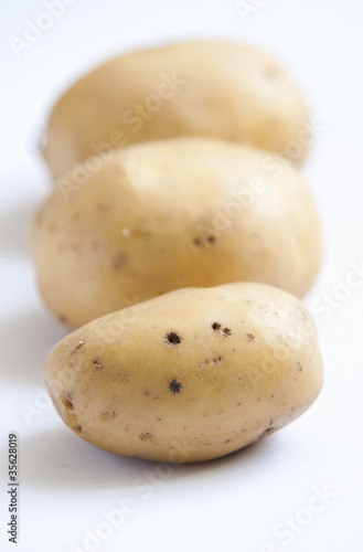 bunch of potatoes on white background close up shoot