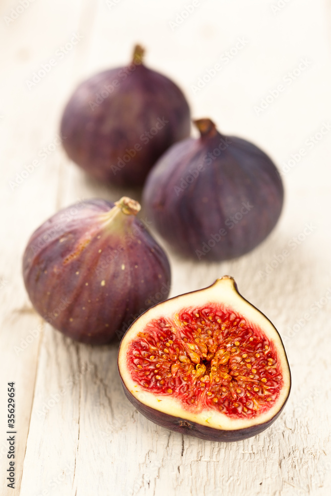 Whole and halved figs on a wooden board Whole and halved figs on a wooden board