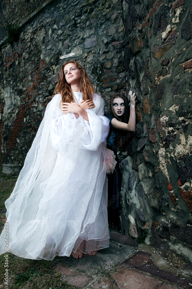 witch and angel against the walls of the old castle witch and angel against the walls of the old castle