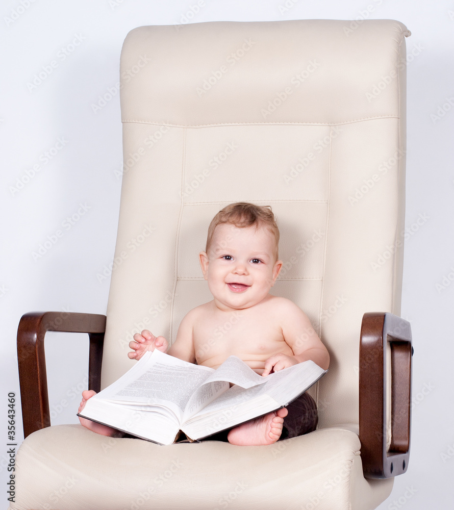 baby boy sitting in office chair reading book baby boy sitting in office chair reading book
