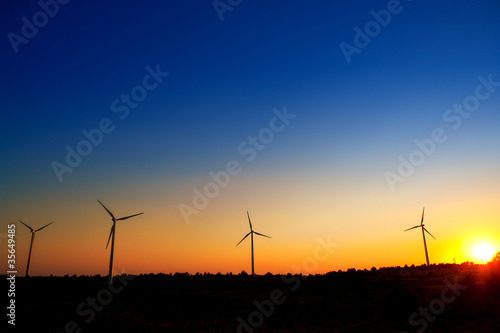aerogenerator windmills on sunset sky