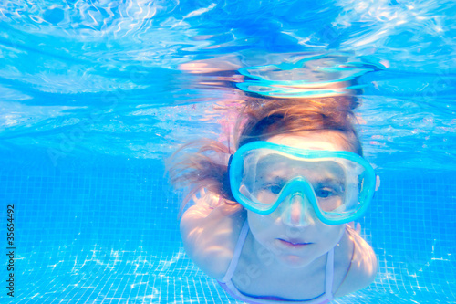 blond child girl underwater swimming in pool