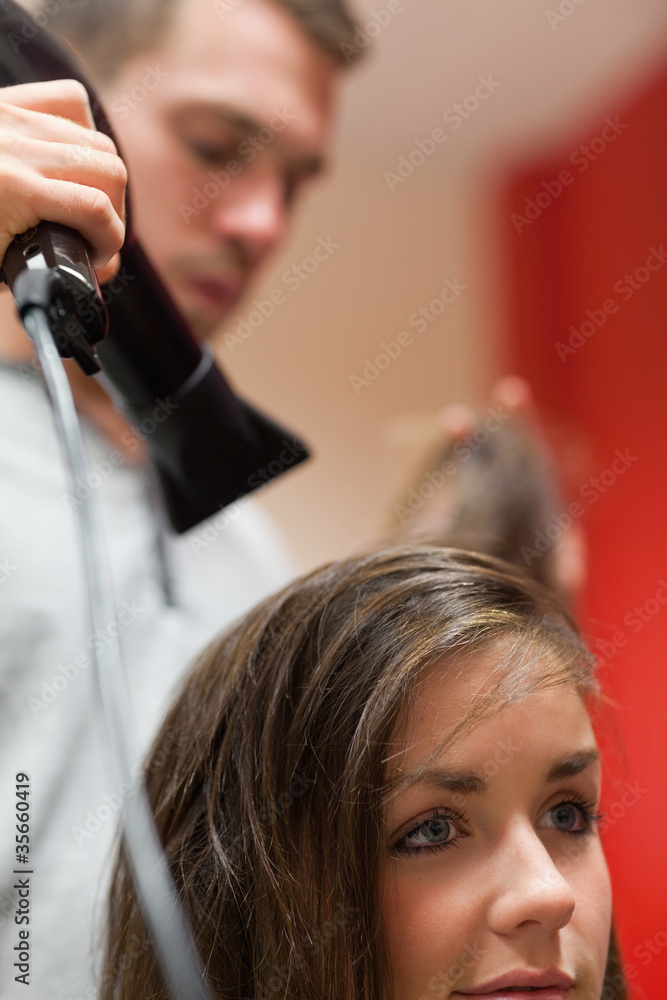 Fototapeta premium Portrait of a handsome hairdresser blowing hair