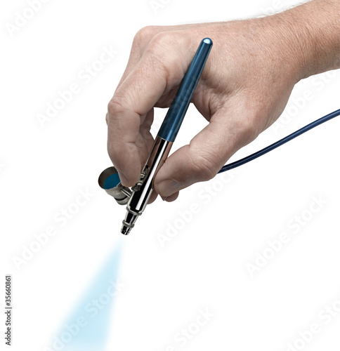 Hand with airbrush painting with cyan color