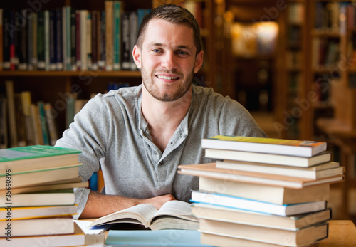 Smiling student surrounded by books