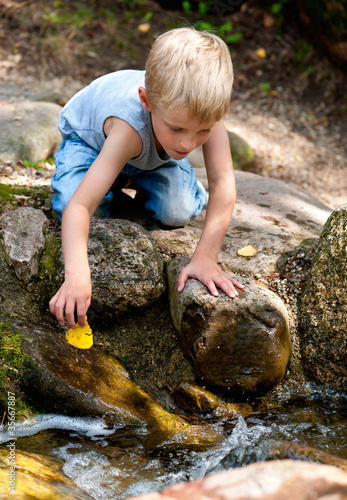 Junge spielt an einem Bach