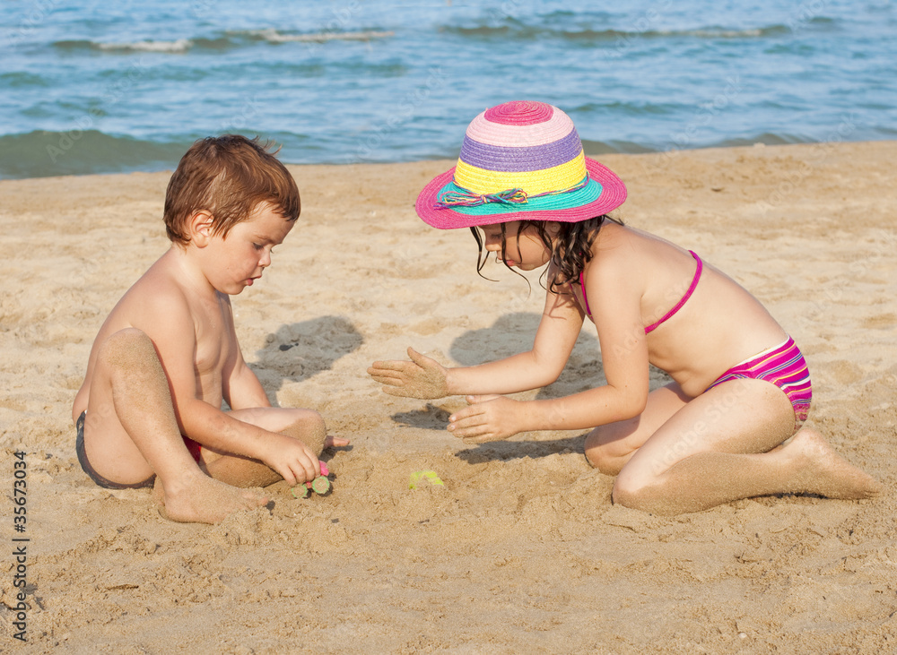 Children building a sand castle on the beach Children building a sand castle on the beach